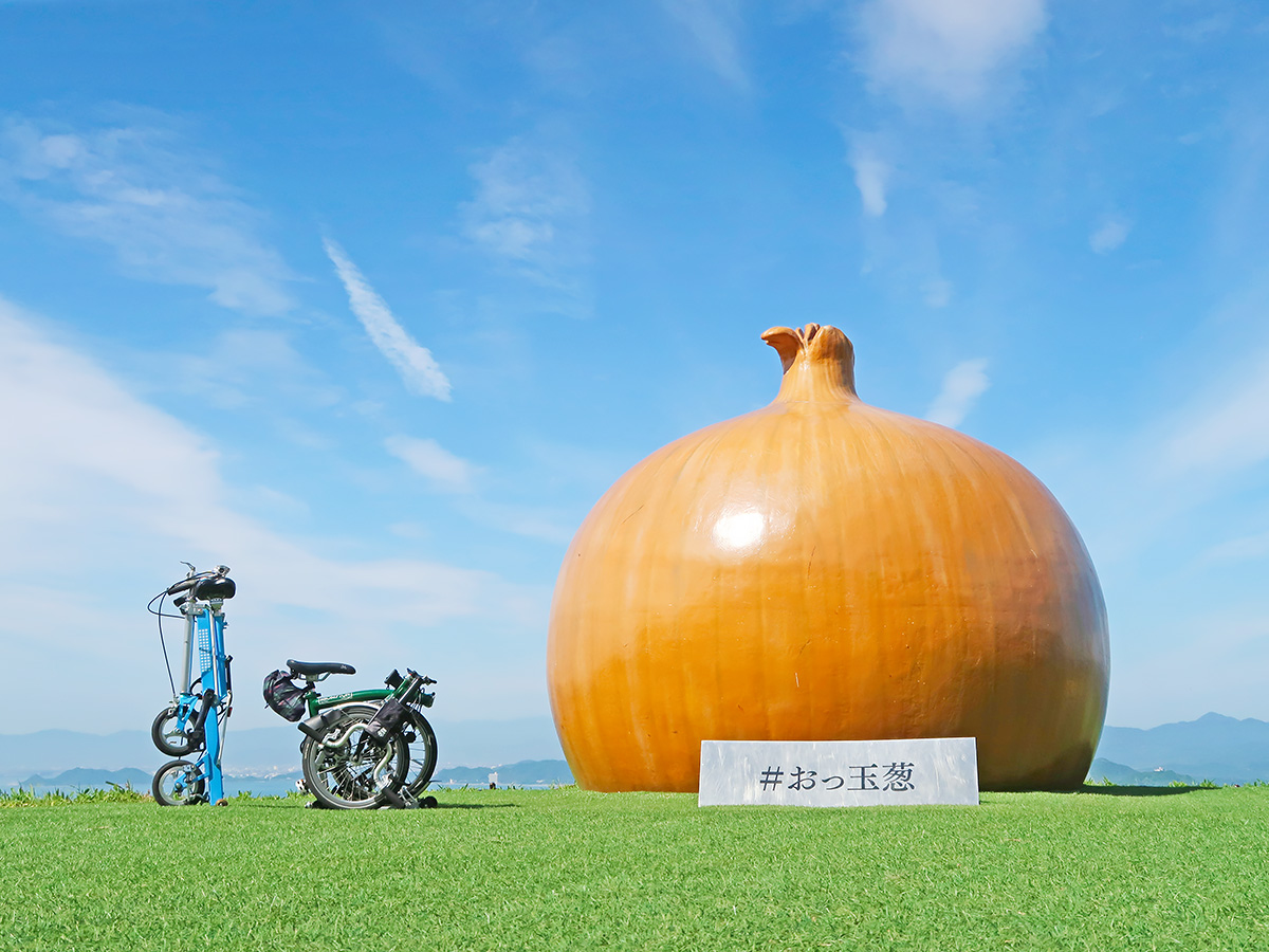 淡路島にある巨大な玉ねぎのオブジェ「おっ玉葱」と自転車を並べた写真