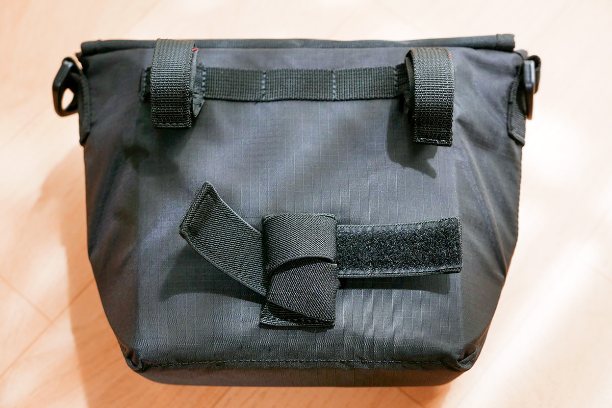 フロントバッグの背面下部のベルトを、ベルト通しに巻き付けることで短く調節した様子