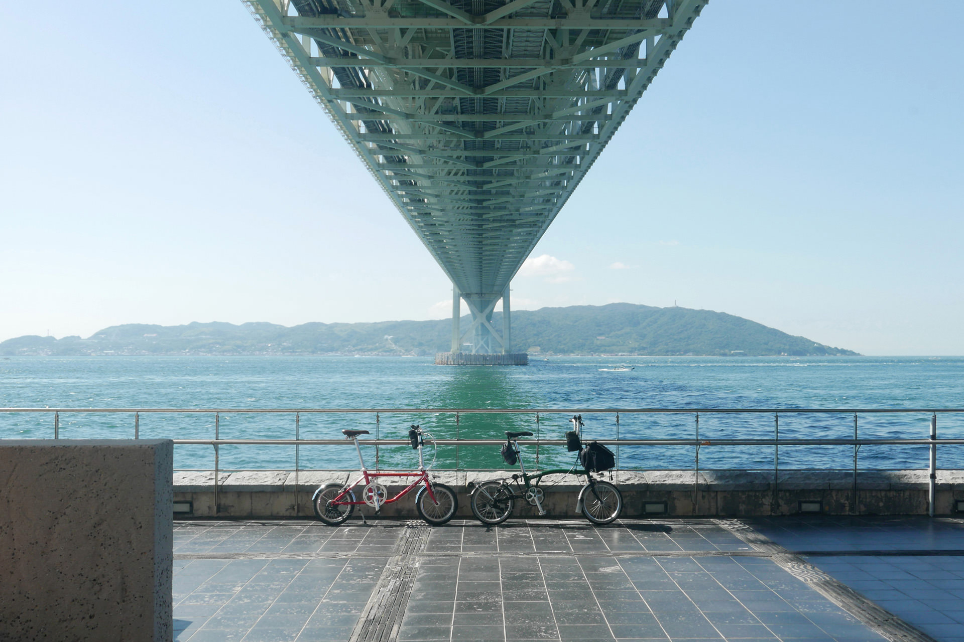 神戸市垂水区の舞子公園内、明石海峡大橋の真下で、2台のミニベロ（BROMPTONとダホンD-Zero）を並べて撮影した写真。