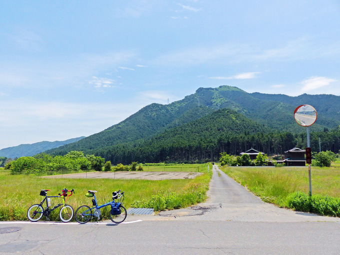 田舎道の写真。田園風景の中に2台の自転車、「ニューワールドツーリスト」と「コメットR」が停められている。