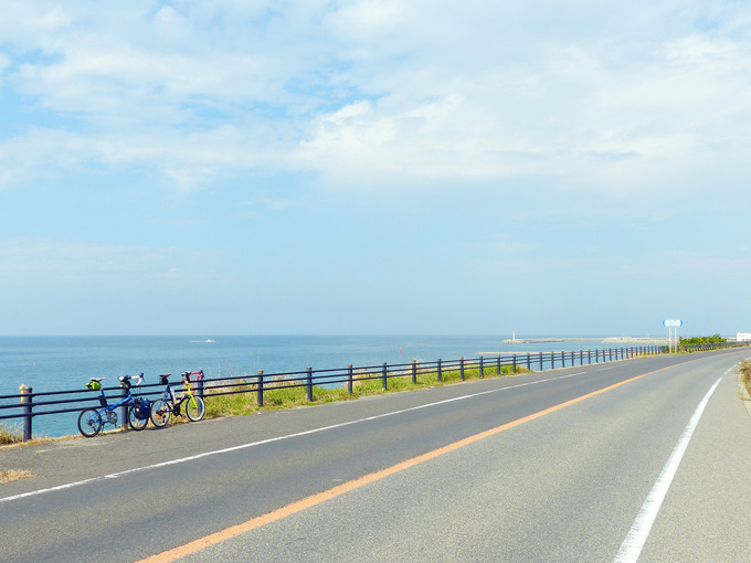 淡路島の西側の海岸線の風景。まっすぐな道路の左側には青い海が広がっている。
