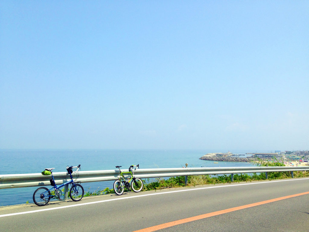 淡路島西側の海岸線の風景に、2台のミニベロを並べた写真