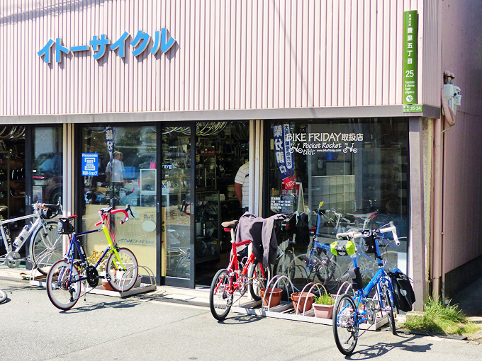 大阪にある自転車屋さん「イトーサイクル」の店舗前の写真。お店の前には筆者の自転車、バイクフライデーの折り畳みミニベロ「ニューワールドツーリスト」と友人の自転車「コメットR」が停められている。お店の窓ガラスには「バイクフライデー取扱店」と書かれている。