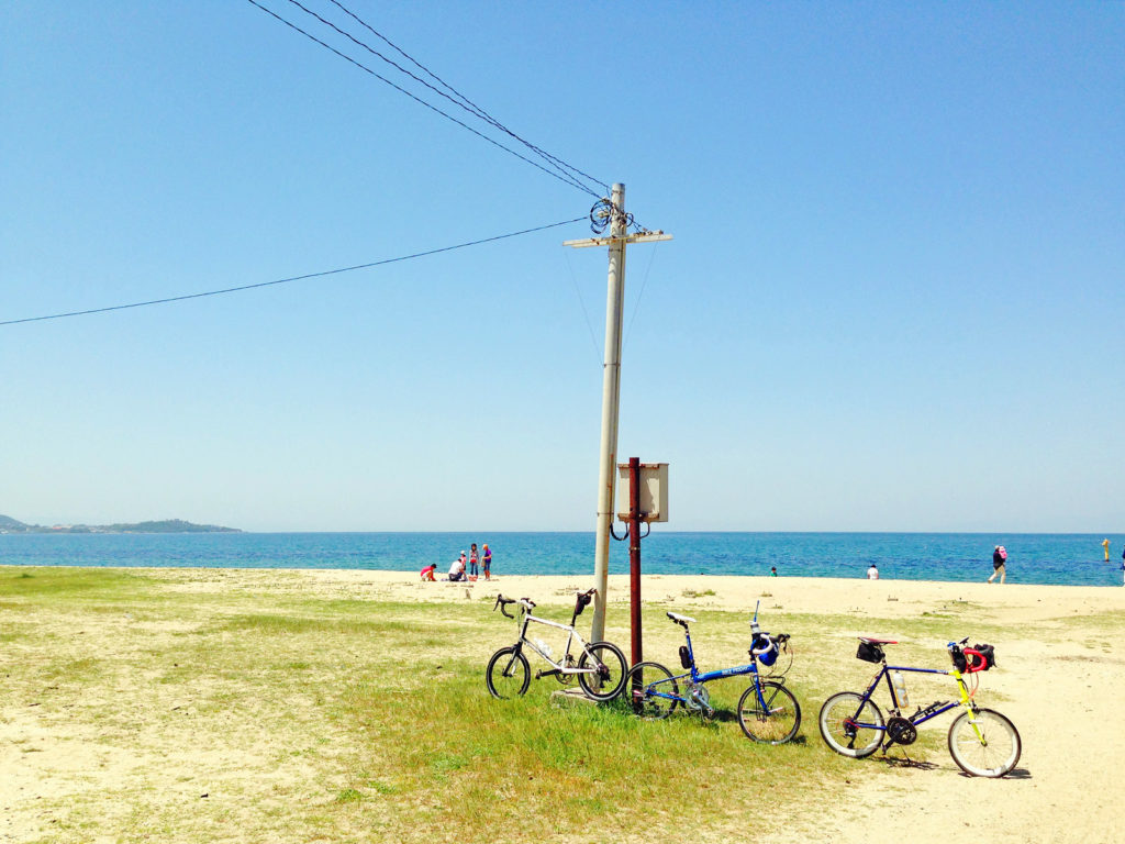 「慶野松原海水浴場」の砂浜の風景に3台のミニベロが停められている写真。